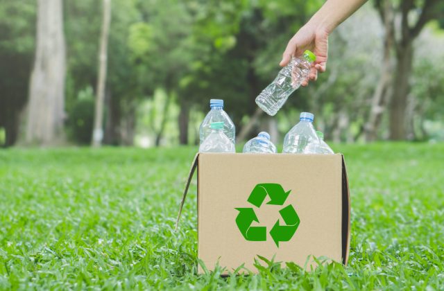 Man hand keep plastic bottle into paper box at public park for r novatex